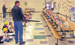 PARENT MIKE EAVES TESTS THE HOUSES THAT STUDENTS BUILT WITH A LEAF BLOWER.