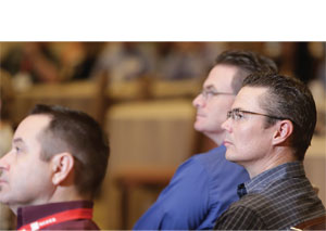 BRIAN KALINA, P.E., (CENTER) OF THE UTAH SOCIETY OF PROFESSIONAL ENGINEERS, LISTENS TO A SPEAKER.