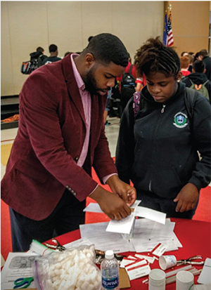 UNLV STUDENT TIMMIE JOHNSON GIVES A STUDENT INSTRUCTION DURING A RECENT STEM OUTREACH EVENT.