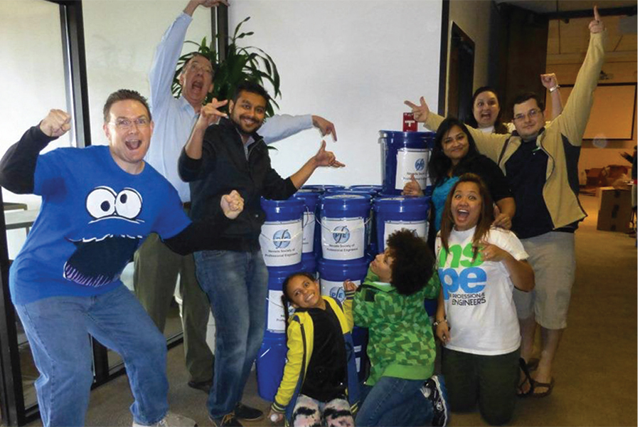 CRAIG SISCO, P.E., F.NSPE; DAVE JAMES, P.E., F.NSPE (FAR LEFT); AND OTHER MEMBERS OF THE NEVADA STEM OUTREACH FOUNDATION CELEBRATE PUTTING TOGETHER BUCKET KITS FOR AN UPCOMING EVENT.