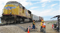 UNIVERSITY OF ILLINOIS RAILTEC STUDENTS AND RESEARCH ENGINEERS UNDERTAKE FULL-SCALE TESTING OF THEIR INSTRUMENTED CONCRETE CROSSTIES AT THE TRANSPORTATION TECHNOLOGY CENTER NEAR PUEBLO, COLORADO.